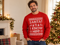 Thumbnail for Man wearing the red Santa I Know Him Christmas sweatshirt beside a decorated Christmas tree.
