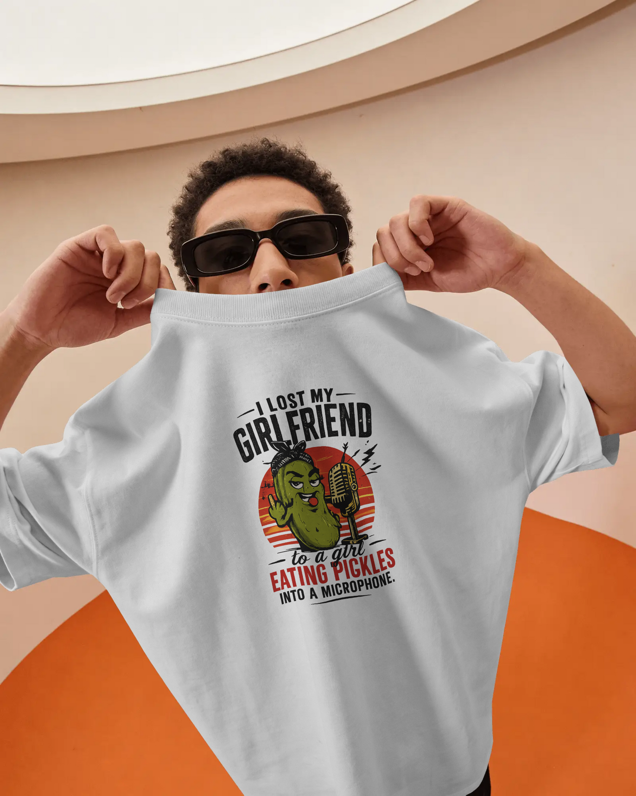 Person wearing a white sweatshirt with a graphic design and text, against a beige and orange background. ASMR Took My Girl - The Pickle Whisperer