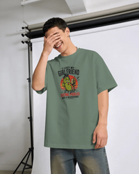 Thumbnail for Person wearing a green t-shirt with a graphic design and text, standing in a studio setting. ASMR Took My Girl - The Pickle Whisperer