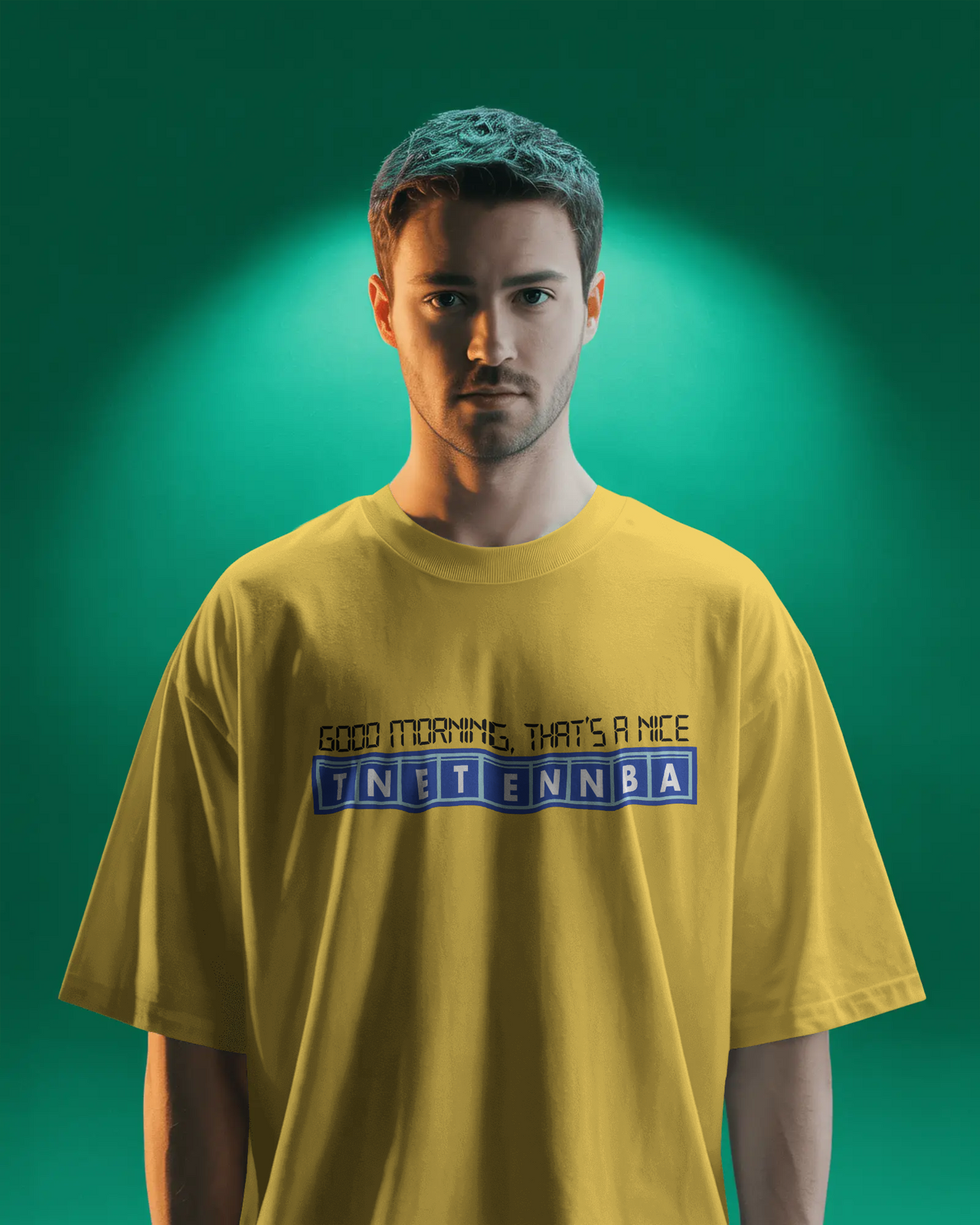 Person wearing a yellow t-shirt with text on a green background - Good Morning That’s A Nice TNETENNBA - The IT Crowd T-Shirt