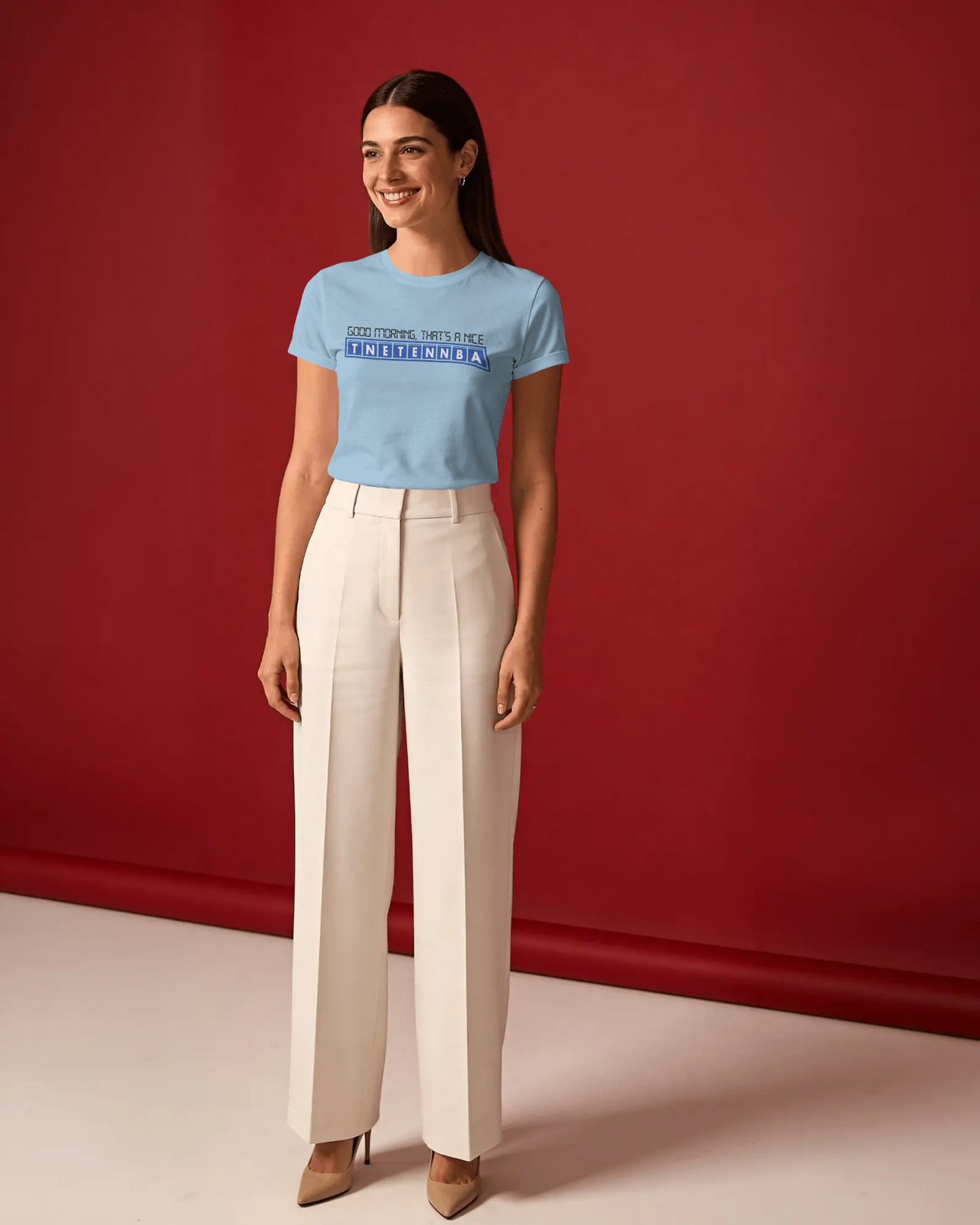 Woman wearing a light blue t-shirt and beige pants against a red background - Good Morning That’s A Nice TNETENNBA - The IT Crowd T-Shirt