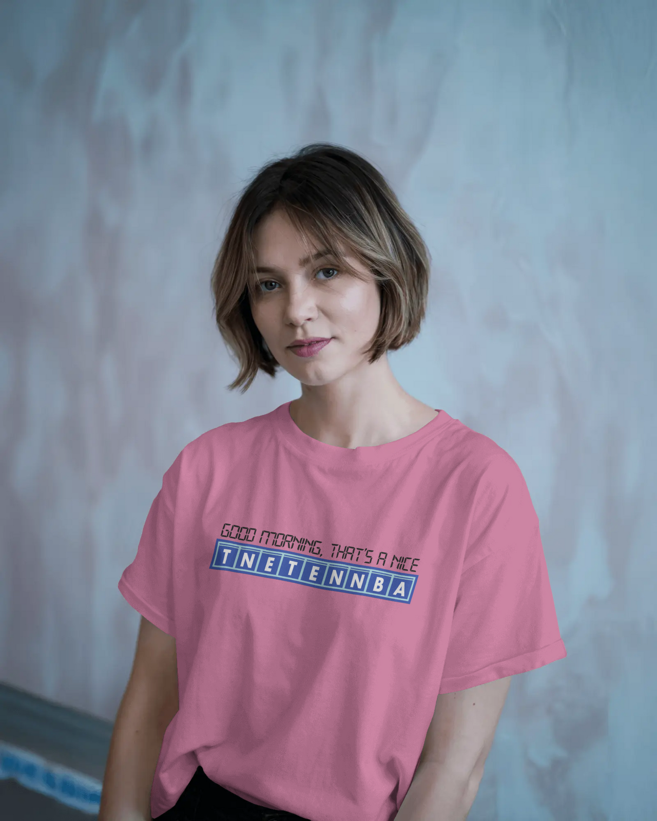Person wearing a pink t-shirt with text against a plain background - IT Crowd - Tnetennba
