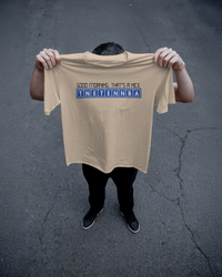 Thumbnail for Person holding a beige t-shirt with text on a dark asphalt background - Good Morning That’s A Nice TNETENNBA - The IT Crowd T-Shirt