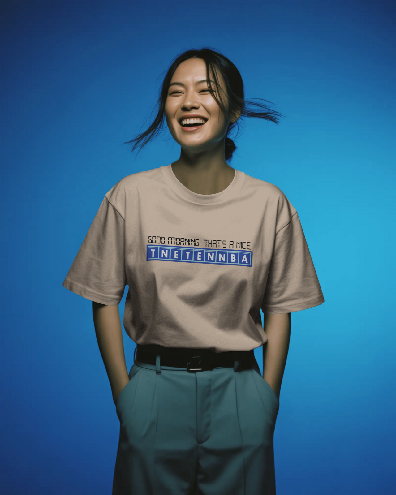 Person wearing a beige t-shirt with text on a blue background - IT Crowd - Tnetennba