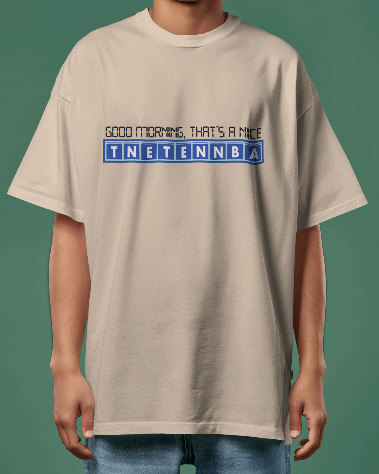Person wearing a beige t-shirt with text design on a green background - IT Crowd - Tnetennba