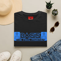 Thumbnail for A folded black t-shirt with a blue and black 'BASS THE FINAL FRONTIER' graphic, styled in a flat lay with a straw hat, white sneakers, blue jeans, sunglasses, and small potted succulents on a light beige background.