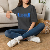 Thumbnail for A woman sitting cross-legged on a woven rug in front of a beige sofa, wearing a dark charcoal heather t-shirt with a blue cassette graphic that reads 'BASS THE FINAL FRONTIER'.