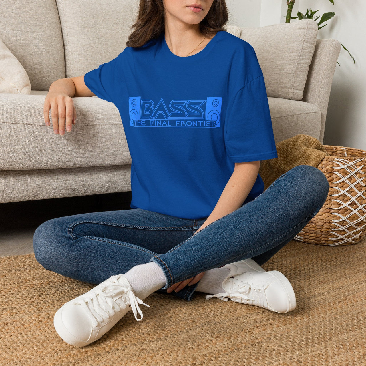 Person wearing a blue t-shirt with graphic design sitting on a couch.