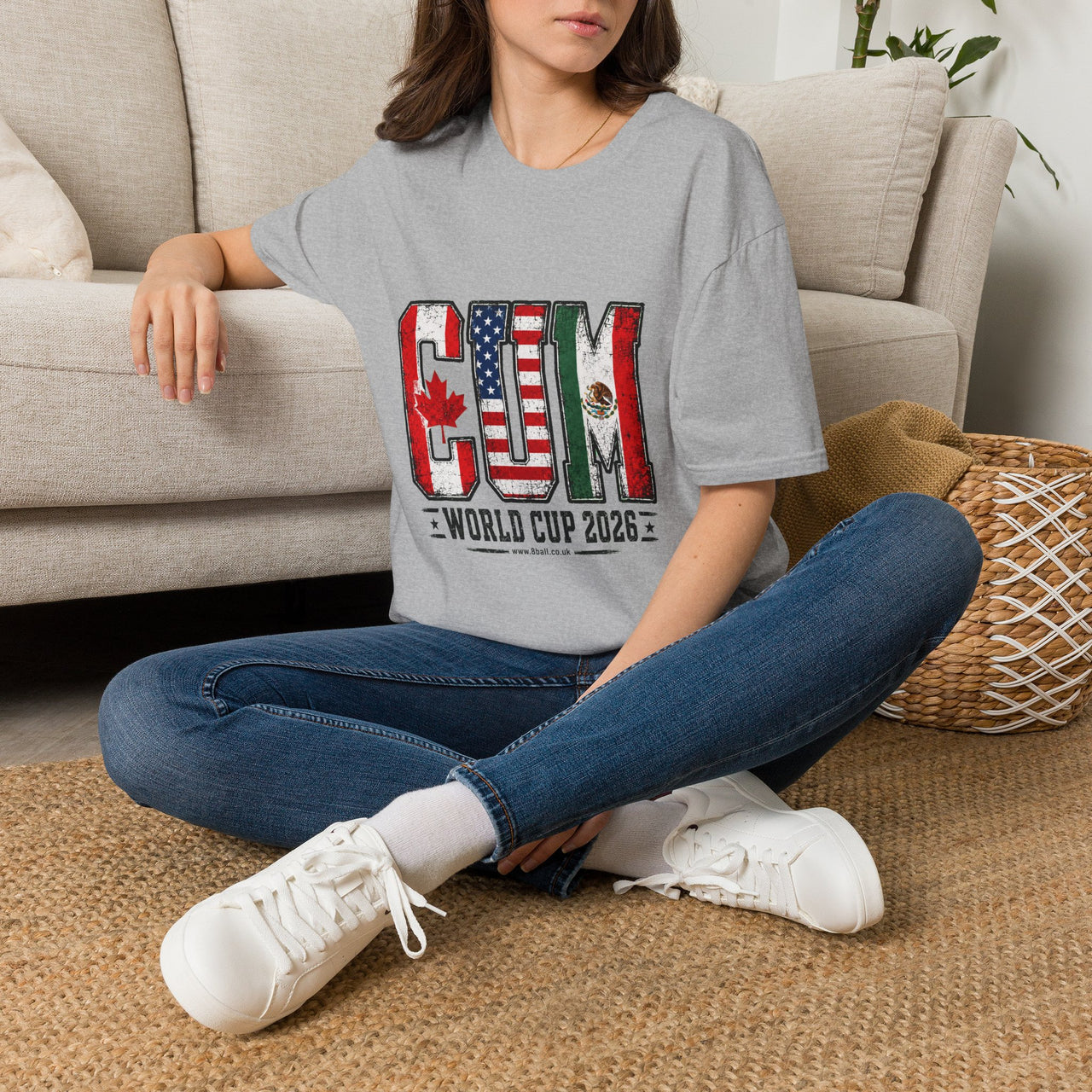 Person sitting on a carpeted floor wearing a gray t-shirt with 'Humanity Under Review' text.