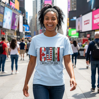 Thumbnail for Person wearing a light blue t-shirt with a World Cup 2026 design in Times Square, New York City.