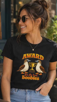 Woman wearing a black Award for the Best Boobies T-shirt, removing sunglasses and pointing to the trophy and birds graphic design.