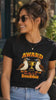 Woman wearing a black Award for the Best Boobies T-shirt, removing sunglasses and pointing to the trophy and birds graphic design.