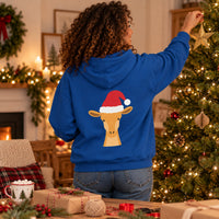 Thumbnail for Santa Giraffe Christmas Back Print Hoodie in Royal, worn in a Christmas home setting with the Santa giraffe back print visible.