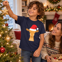 Thumbnail for Santa Giraffe Christmas Kids T-Shirt in Navy, worn in a Christmas home setting with the Santa giraffe front print visible.