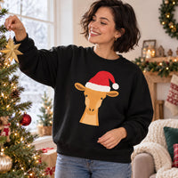 Thumbnail for Santa Giraffe Christmas Sweatshirt in Black, worn in a Christmas home setting with the Santa giraffe front print visible.