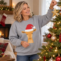 Thumbnail for Santa Giraffe Christmas Sweatshirt in Sport Grey, worn in a Christmas home setting with the Santa giraffe front print visible.