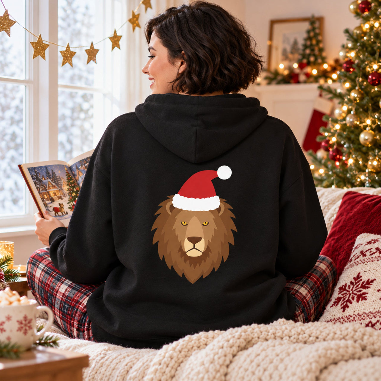 Santa Lion Christmas Back Print Hoodie in Black, worn in a Christmas home setting with the Santa lion back print visible.