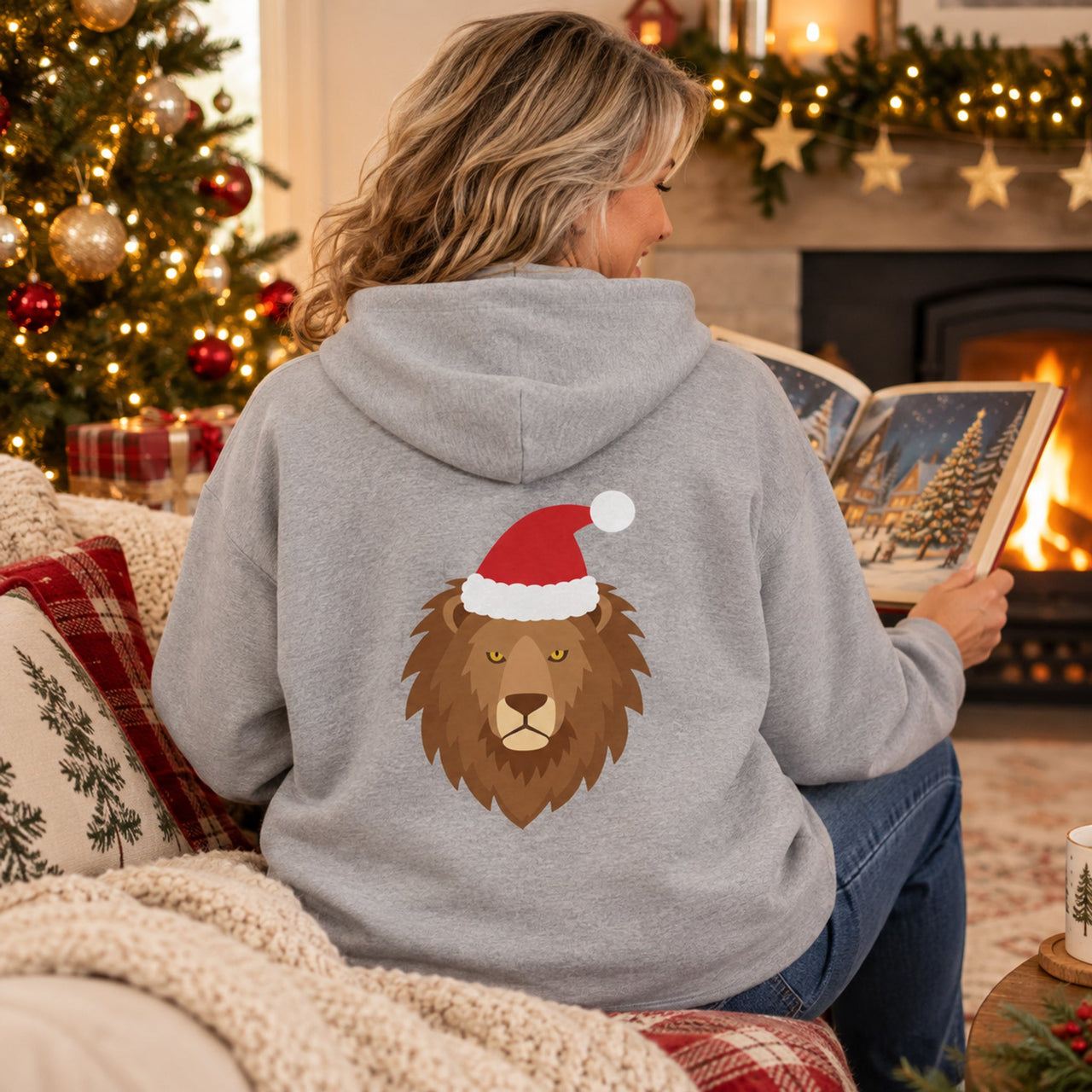 Santa Lion Christmas Back Print Hoodie in Sport Grey, worn in a Christmas home setting with the Santa lion back print visible.