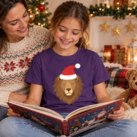 Thumbnail for Santa Lion Christmas Kids T-Shirt in Purple, worn in a Christmas home setting with the Santa lion front print visible.