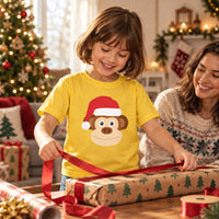 Thumbnail for Santa Monkey Christmas Kids T-Shirt in Daisy, worn in a Christmas home setting with the Santa monkey front print visible.