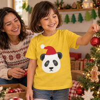 Thumbnail for Santa Panda Christmas kids t shirt in Daisy, worn in a festive home setting with the Santa panda front print visible.