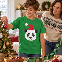 Thumbnail for Santa Panda Christmas kids t shirt in Irish Green, worn in a festive home setting with the Santa panda front print visible.