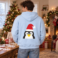 Thumbnail for Santa Penguin Christmas back print hoodie in Light Blue, worn in a Christmas home setting with the Santa penguin back print visible.