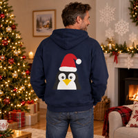 Thumbnail for Santa Penguin Christmas back print hoodie in Navy, worn in a Christmas home setting with the Santa penguin back print visible.
