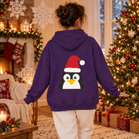 Thumbnail for Santa Penguin Christmas back print hoodie in Purple, worn in a Christmas home setting with the Santa penguin back print visible.