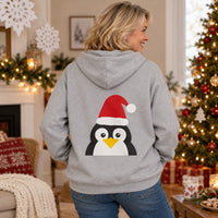 Thumbnail for Santa Penguin Christmas back print hoodie in Sport Grey, worn in a Christmas home setting with the Santa penguin back print visible.
