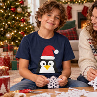 Thumbnail for Santa Penguin Christmas kids t shirt in Navy, worn in a Christmas home setting with the Santa penguin front print visible.