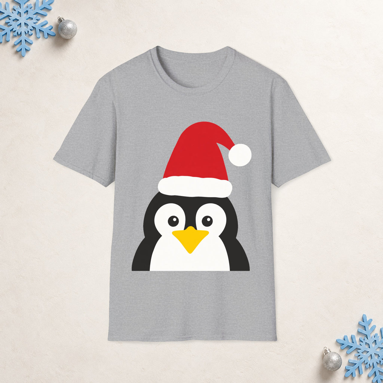 Santa penguin Christmas unisex t shirt in Sport Grey, front view with the Santa animal illustration on a Christmas flat-lay background.