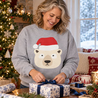 Thumbnail for Santa Polar Bear Christmas sweatshirt in Sport Grey, worn in a Christmas home setting with the Santa polar bear front print visible.
