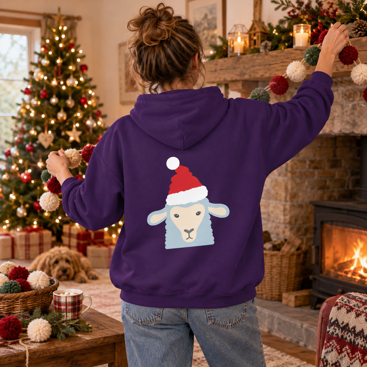 Santa Sheep Christmas Back Print Hoodie in Purple, worn in a Christmas home setting with the Santa sheep back print visible.