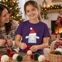 Thumbnail for Santa Sheep Christmas Kids T-Shirt in Purple, worn in a Christmas home setting with the Santa sheep front print visible.