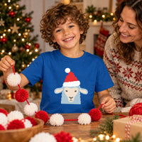Thumbnail for Santa Sheep Christmas Kids T-Shirt in Royal, worn in a Christmas home setting with the Santa sheep front print visible.