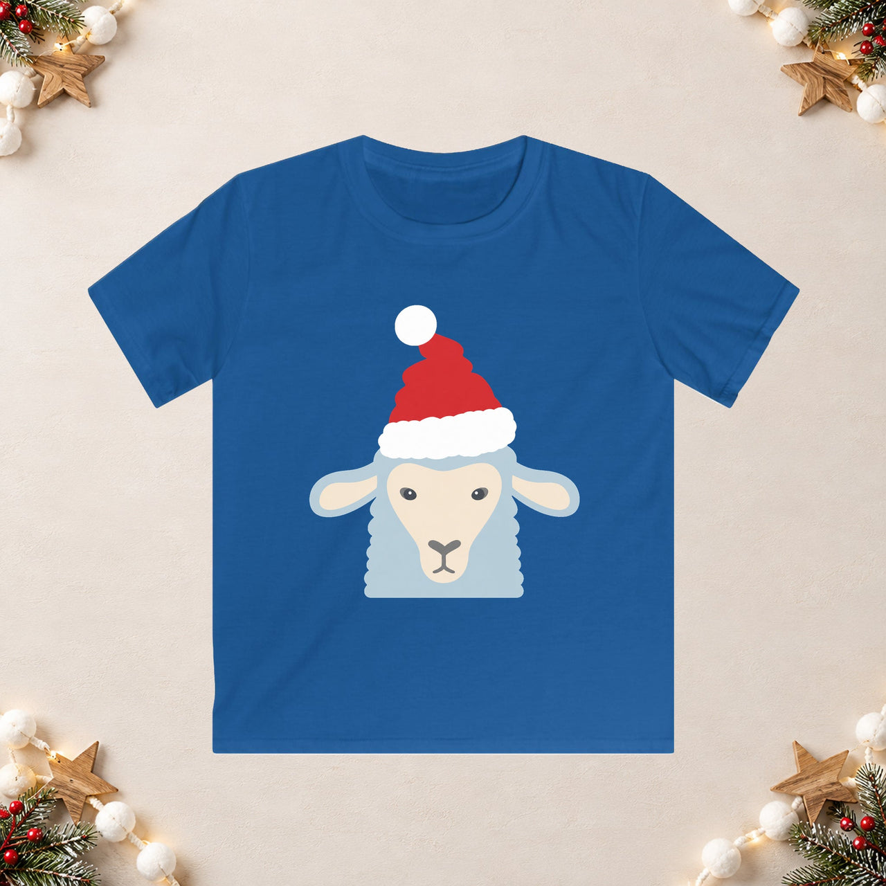 Santa sheep Christmas kids t shirt in Royal, front view with the Santa animal illustration on a Christmas flat-lay background.